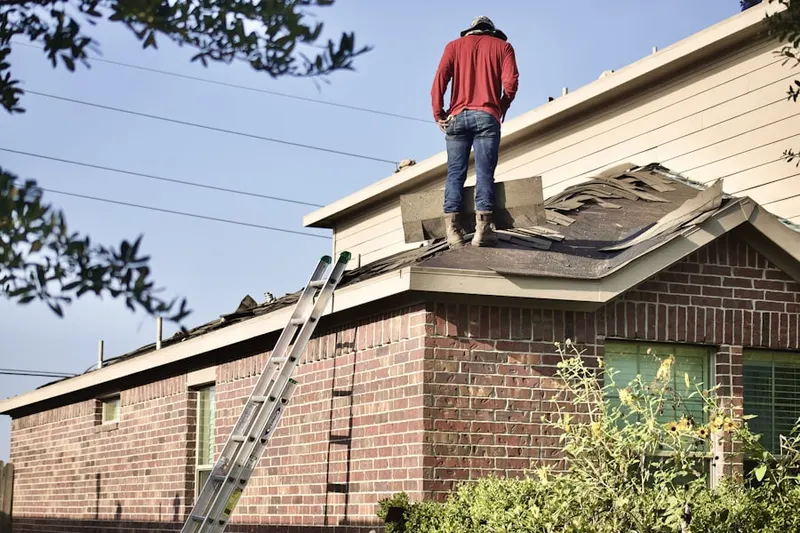 Professional roofer working on a residential roof in Milam-Jones